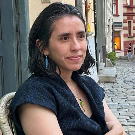 Dr. Daniela Castellanos Montesis sitting in a chair on a cobblestone street