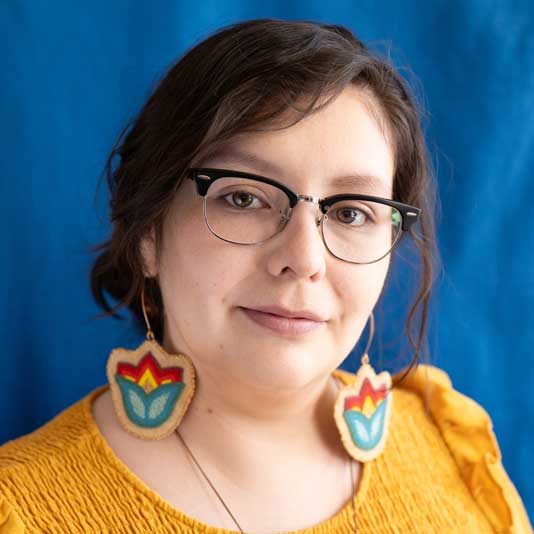 Franchesca Hebert-Spence wearing glasses, beaded earrings, and a yellow top