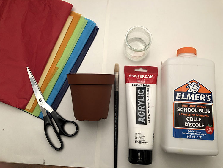 Craft materials including tissue paper glue, sciessors, a flower point, and white paint