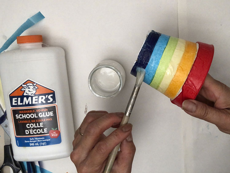 Gluing colourful strips of tissue paper onto a pot