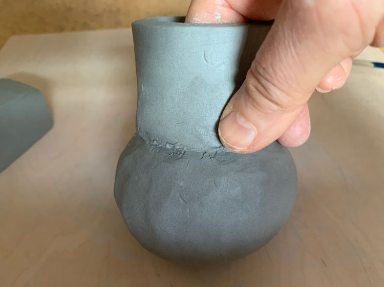 Smoothing the seam of a clay pinch pot
