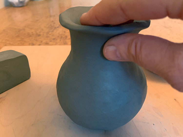 Clay pinch pot with a flared neck