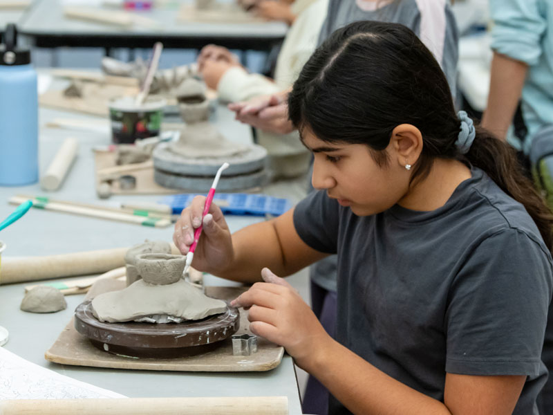 A young girl with working with clay in the studio