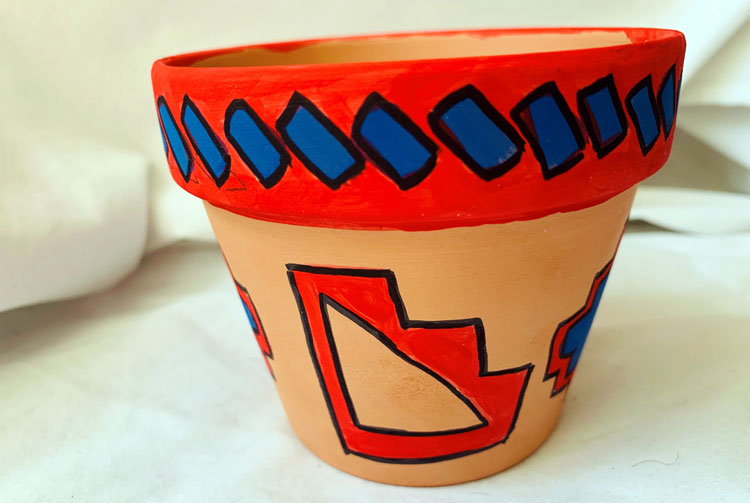 Clay pot with red and blue geometric designs