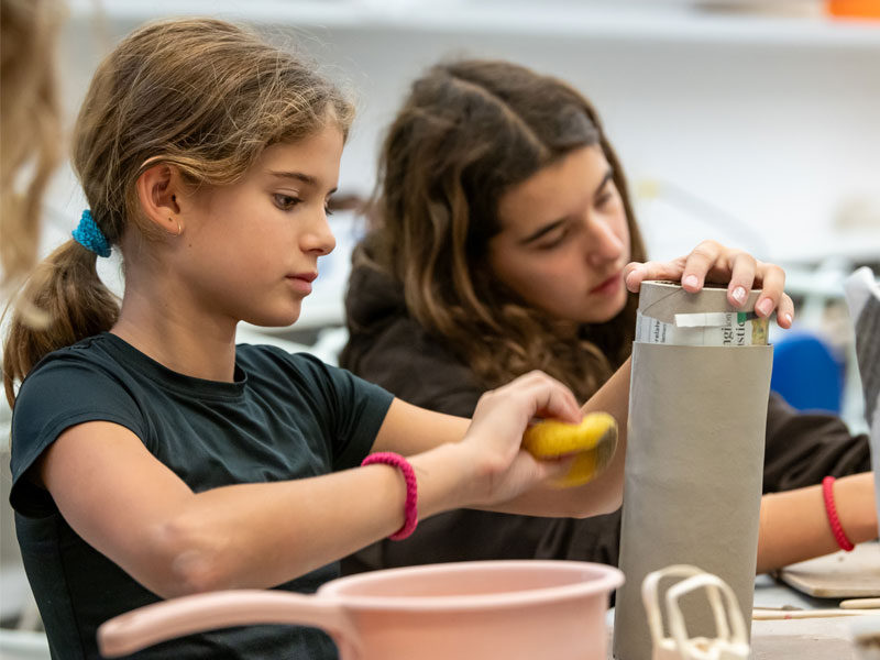 Two girls making pottery in the studio