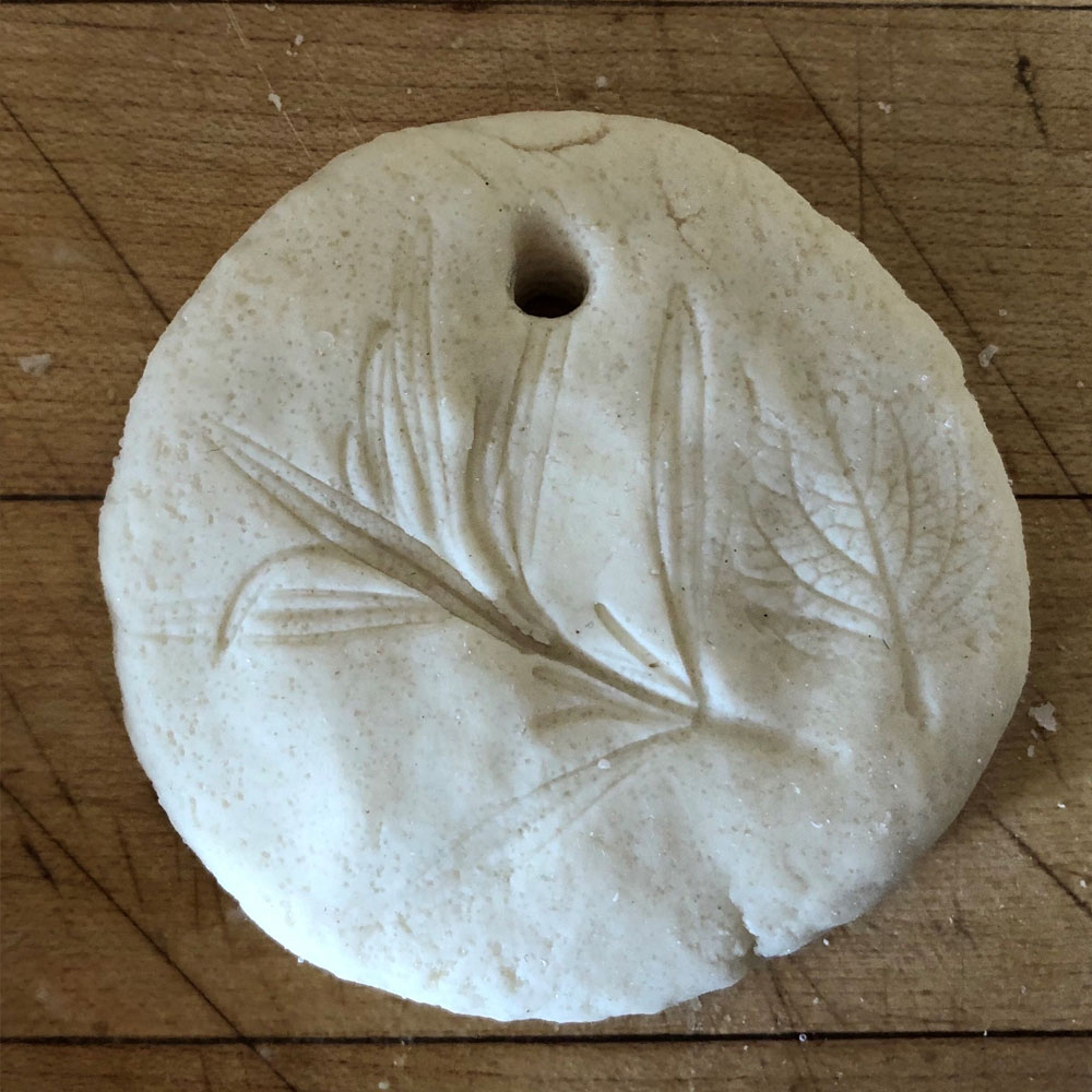 Dough medallion with impression of a leaf