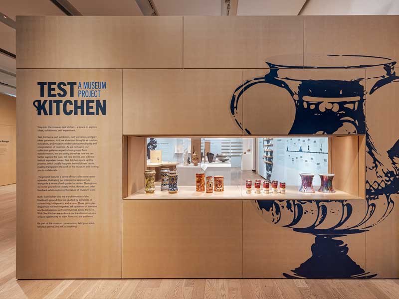 A wood wall with a glass case filled with ceramic objects