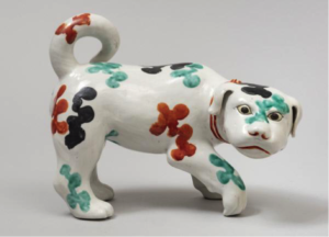 A ceramic dog with red, blue, and turquoise flowers painted on it