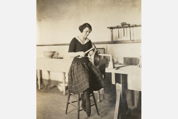 Newcomb College student forming a metal bowl, c. 1920, Newcomb Art School Scrapbook, University Archives, Tulane University